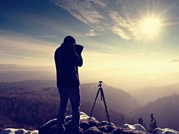 Professional nature photographer on snowy cliff. — Stock Photo, Image