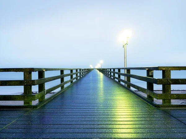 Mattina nebbiosa autunnale sul molo di legno sopra il mare. Depressione, atmosfera oscura . — Foto Stock