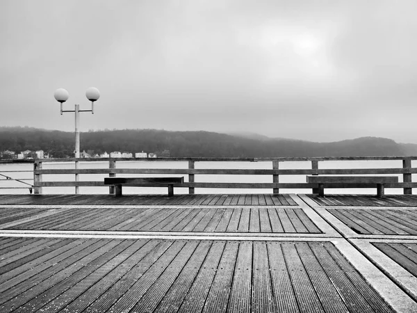 Podzimní mlhavé ráno na dřevěném molu nad mořem. Deprese, temná atmosféra. — Stock fotografie