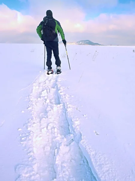 Caminhante com mochila snowshoeing em deriva profunda. Homem com caminhada na colina . — Fotografia de Stock