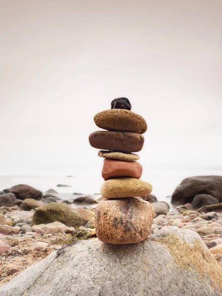 Pirámide de piedras que simboliza zen, armonía, guijarros de equilibrio. Océano en el fondo —  Fotos de Stock