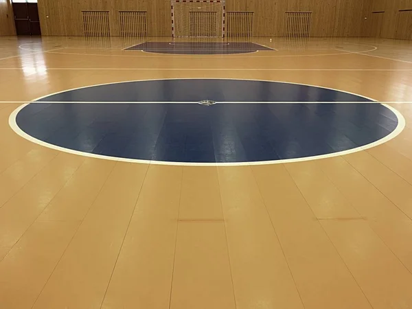 Γήπεδο μπάσκετ στο εσωτερικό. Λευκές γραμμές και μπλε playfield στην αίθουσα. Hanball πύλη στο τείχος. Ζωγραφισμένο ξύλινο πάτωμα του sports hall με πολύχρωμο σήμανση γραμμές. Schooll αίθουσα γυμναστικής — Φωτογραφία Αρχείου