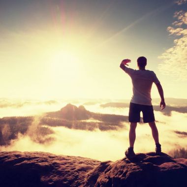 Zafer rock Zirvesi havada rams ile mutlu bir adam jesti