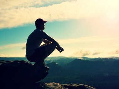 Adam turist rock İmparatorluğu üzerinde oturup özgürlük tadını çıkarın. Rüya gibi manzara 