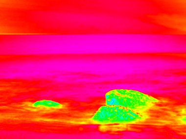Kızılötesi. . Taşlı okyanus plaj ile büyük kayalar. Termografi etkisi.