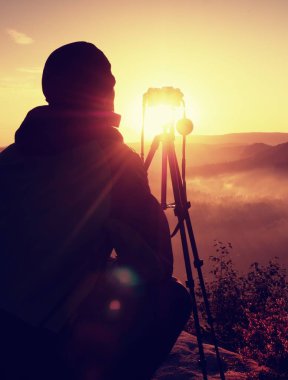 Fotoğrafçı kaya tepe üzerinde kamera ile fotoğraf çeker