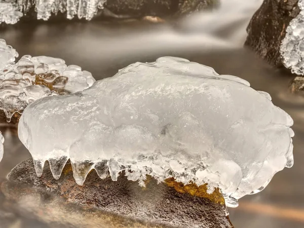 Piece of rystal ice with cracks inside. Fallen icicle bellow waterfall, stony and messy stream bank. Extreeme freeze — Stock Photo, Image