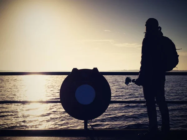 Gebückte Künstler-Fotografie mit Kamera auf Stativ. Tourist am Geländer — Stockfoto