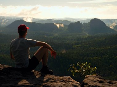 Adam turist rock İmparatorluğu üzerinde oturup özgürlük tadını çıkarın. Rüya gibi manzara 