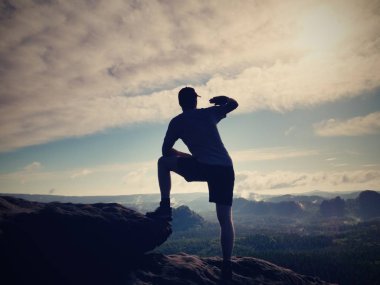 Genç uzun yürüyüşe çıkan kimse siyah pantolon ve gömlek kenarında, vadiye bak