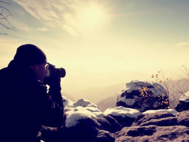 Uzun boylu adam boyunda ayna kamerayla fotoğraf çekiyorum. Karlı kaya