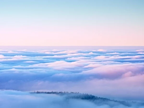 Topparna av bergen ovanför krämig mist, vinter landskap. — Stockfoto