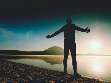 Kumsalda egzersiz adam. Egzersiz ve gölde germe etkin adam silüeti