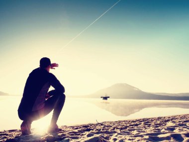 Kumsalda egzersiz adam. Egzersiz ve gölde germe etkin adam silüeti