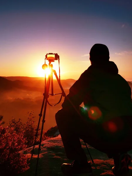 Fotograf tar bilder med kameran på toppen av rock — Stockfoto