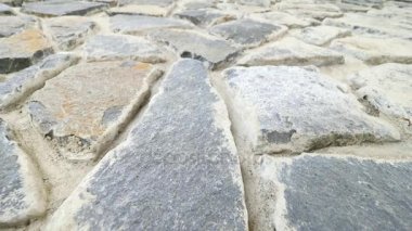 Kırık düz taşlarla örülmüş duvar inşa. Eski taşlı duvar doğa malzemesi ve beton, kırık marl taşlar, geleneksel yapı malzemeleri. 