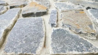 Kırık düz taşlarla örülmüş duvar inşa. Eski taşlı duvar doğa malzemesi ve beton, kırık marl taşlar, geleneksel yapı malzemeleri. 
