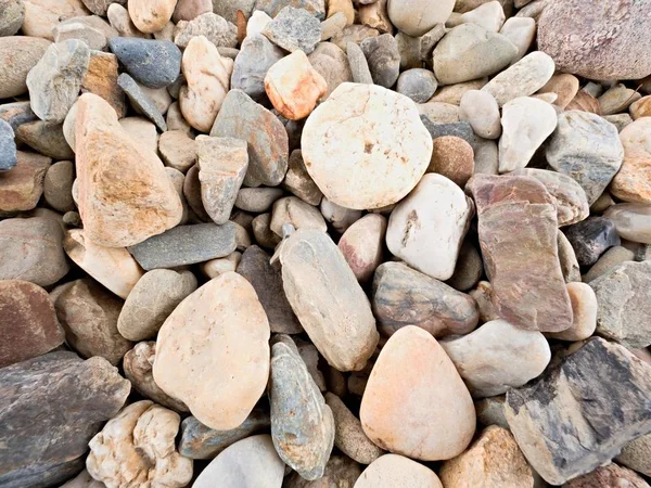 Stary kamienisty bruk z naturalny żwir, suche zaokrąglone i kolorowe kamyki. — Zdjęcie stockowe