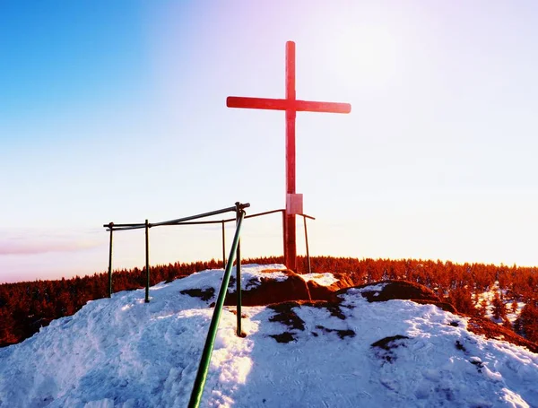 Modest wooden cross on rocky summit. Memory of victims