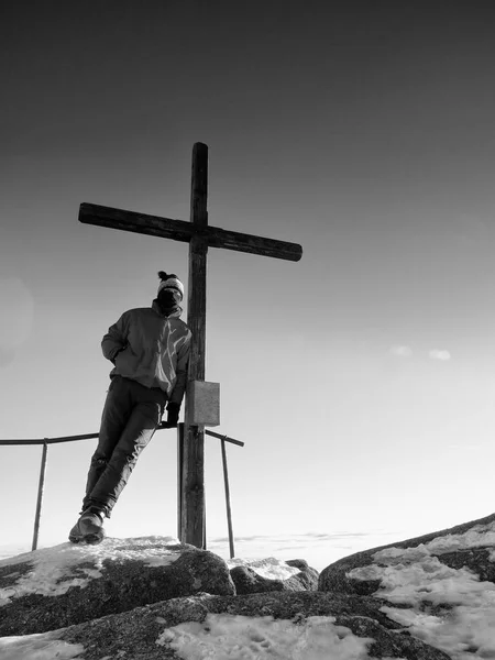 Muž tramp v teplé oblečení na summit s dřevěný kříž. — Stock fotografie