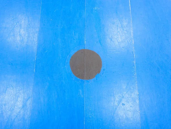 Černý bod v modré hřiště. Malované dřevěné podlahy sportovní haly — Stock fotografie