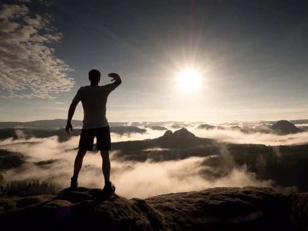 Mannen i toppen av ett berg som ser det dimmiga landskapet. Känn dig fri — Stockfoto