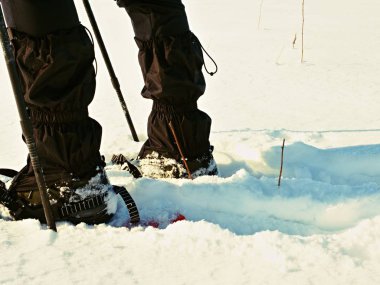 Kar ayakkabılarını ayaklı adam karda yürümek. Kış detayını zammı rüzgârla oluşan kar yığını içinde snowshoeing 