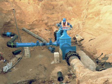 Emanet kıyafet işçi sürücü kapak iletken şehir içme suyu boru üzerinde 