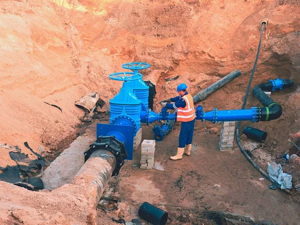 Canalisation d'approvisionnement en eau de Main City. Personnel technique en gilet réfléchissant souterrain — Photo