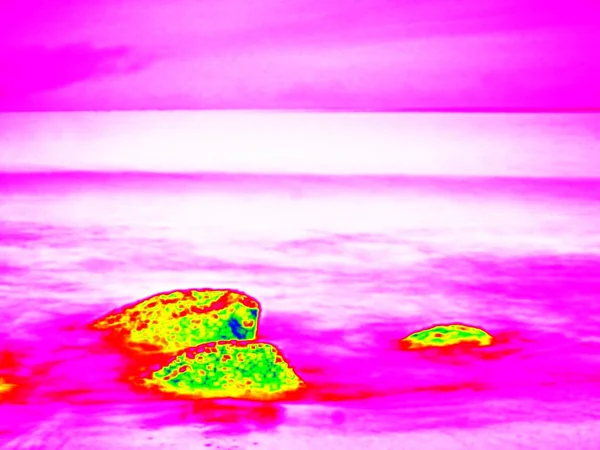 Infra. . Stony ocean beach with big boulders. Thermography effect. — Stock Photo, Image