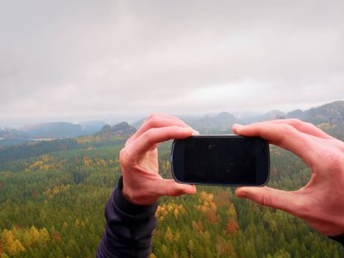 Siyah telefon ekran. Karanlık mobil ekran. Adam el alır akıllı telefon ile fotoğraf kaya tepe üzerinde