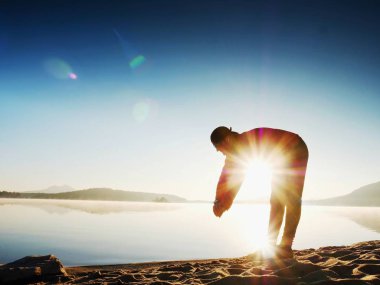 Derin nefes alma runner siluet elleriyle diz çöküyorum. Kas germe adama yan görünüm 