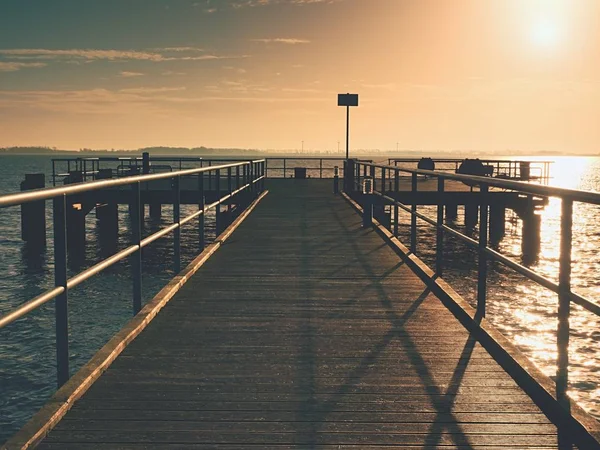 Largo muelle de madera en la costa, mañana fría, tranquilo día silencioso — Foto de Stock