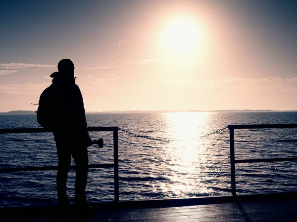Mann, Fotograf beim Fotografieren am See bei Sonnenuntergang. Hobbyfotograf im Urlaub. — Stockfoto