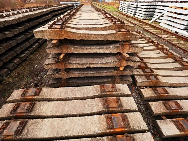 Used sleepers stock in railway depot. Old, dirty and rusty used concrete railway ties stored — Stock Photo, Image