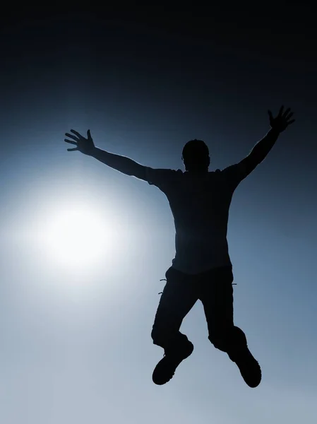 El hombre vuela en el aire. Efecto Tonificado Azul. Hombre cayendo con las manos arriba . — Foto de Stock