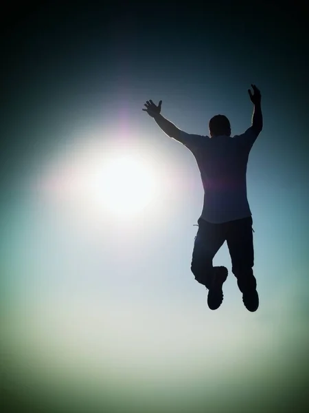 El hombre vuela en el aire. Efecto Tonificado Azul. Hombre cayendo con las manos arriba . — Foto de Stock