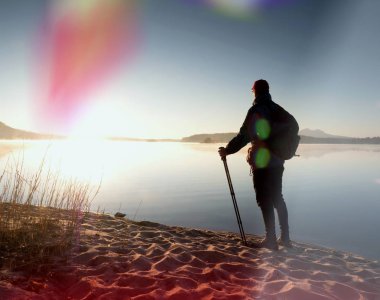 Uzun boylu Polonyalılar ve sportif sırt çantası ile koyu spor giyim uzun yürüyüşe çıkan kimse sahilde yürümek. Turistik zevk gündoğumu 