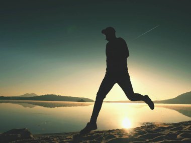 İnce genç fitness adam plaj, tropikal iz runner runner. Neşeli sporcu kumsalda koşmak