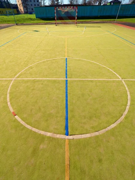 Espaço livre vazio do handball, superfície verde peluda plástica na terra e linhas azuis brancas dos limites . — Fotografia de Stock