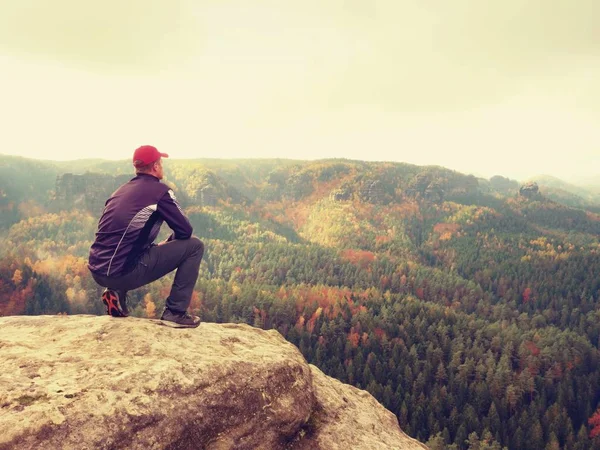 Reiseführer in schwarz. Wanderer mit Sportbekleidung stehen auf Aussichtspunkt über dem Tal der Herbstfarben. — Stockfoto