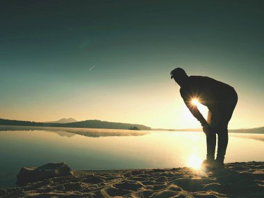 Derin nefes alma runner siluet elleriyle diz çöküyorum. Kas germe adama yan görünüm 