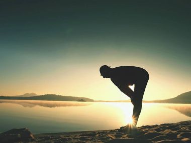 Derin nefes alma runner siluet elleriyle diz çöküyorum. Kas germe adama yan görünüm 