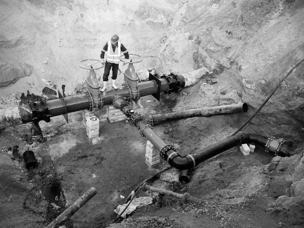 Trabajador subterráneo en la válvula de compuerta en el sistema de agua potable, waga varios miembros conjuntos . — Foto de Stock