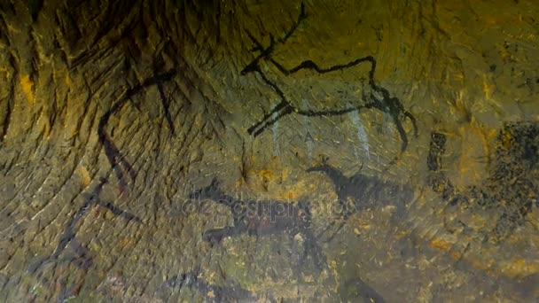 Peinture de chasse humaine aux cerfs, aux mammouths et aux rennes. Art abstrait historique en carbone noir dans une grotte de grès sous une faible lumière. Découverte de la peinture préhistorique de la chasse aux hommes des cavernes en grès . 