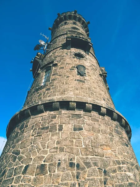 The stony tower  on the peak of rocky hill. Early morning sunshine, blue sky, dry  stony walls. — Stock Photo, Image