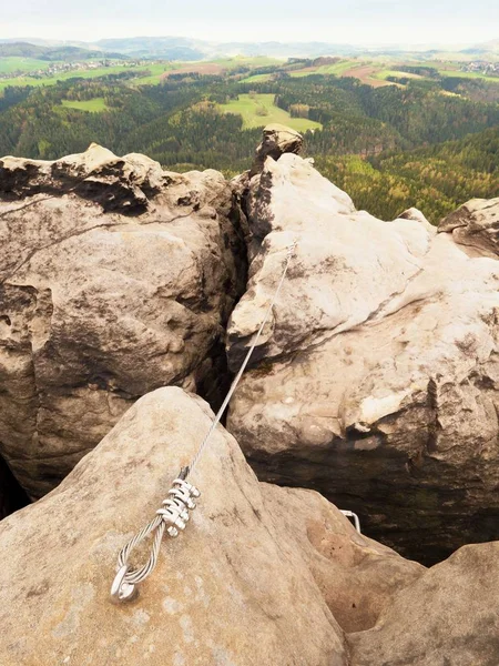 Железная скрученная веревка, растянутая между скалами в патче альпинистов через феррату. Веревка закреплена в скале — стоковое фото