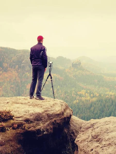 Fotógrafo adulto alto prepara câmera para tirar fotos de montanhas de outono . — Fotografia de Stock