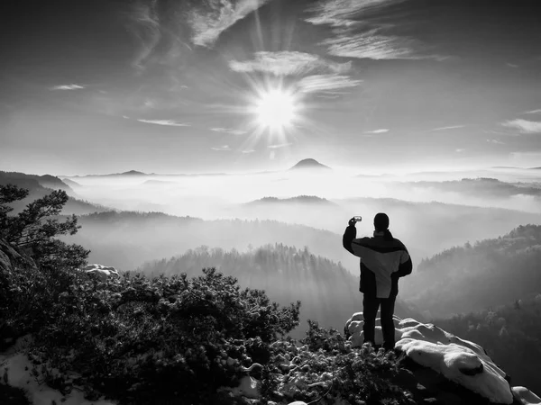 Fotógrafo de telefone tira foto de congelamento paisagem montanhosa — Fotografia de Stock