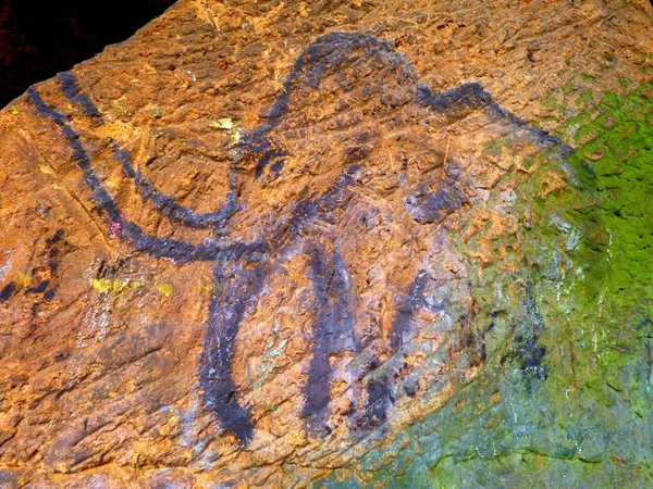 Arte prehistórico de mamut en cueva de arenisca. El foco brilla sobre la pintura histórica — Foto de Stock